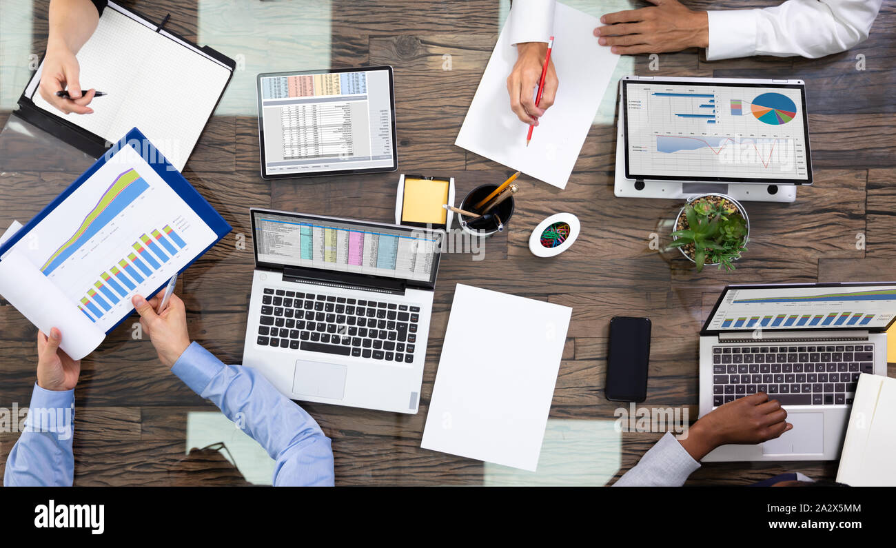 Elevato angolo di visione di un team di dirigenti aziendali discutendo sui dati in Sala Riunioni Foto Stock