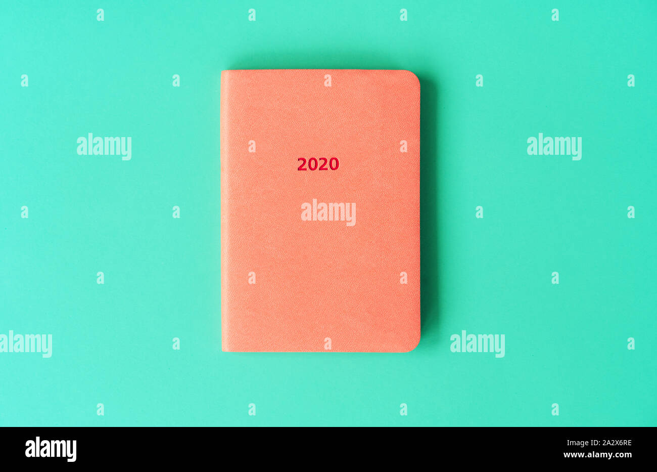 Diario di colore arancione per il 2020 su un sfondo di menta. Anno nuovo concetto in colori alla moda. Foto Stock