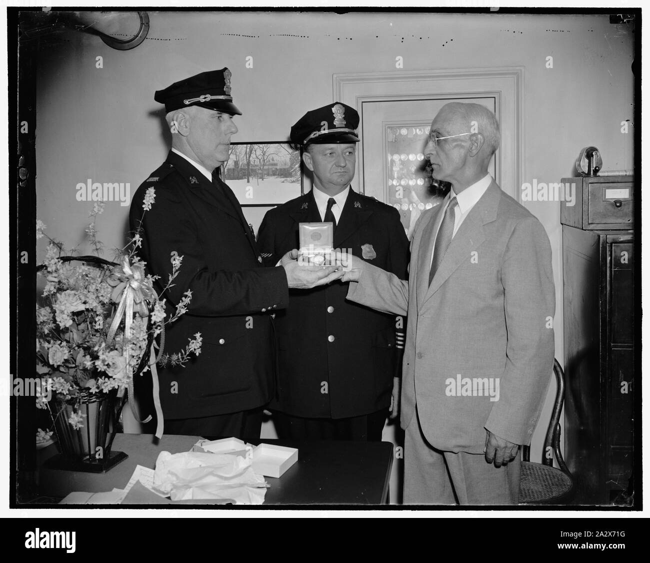 Premio per 22 anni di servizio alla Casa Bianca. Washington D.C., il 6 luglio. Pensione dopo 22 anni sulla Casa Bianca forza di polizia, il capitano Alpheus Walter, a destra è stata presentata con un orologio oggi da memebers della forza alla Casa Bianca, la presentazione è stata fatta da Capt. John D. McCubbin, sinistra; chi alleviato Walter e Lieut; Herbert Marcey, centro che ha preso il posto McCubbins come Lieut., 7/6/38 Foto Stock