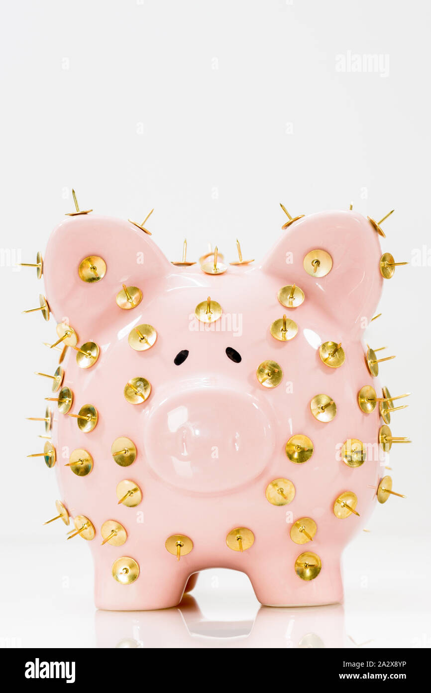 Immagine concettuale che illustra la protezione dei risparmi e degli investimenti che mostra una banca rosa piggy protetta da tacchi di disegno e isolata contro il bianco. Foto Stock