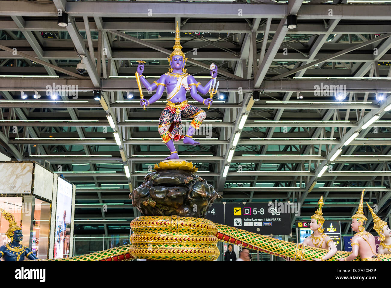Ramayana Angelo tradizionale tailandese catturato serpente o Naga scultura statua (tre capi serpente) nella zona partenze dell'Aeroporto Internazionale di Suvarnabhumi Foto Stock