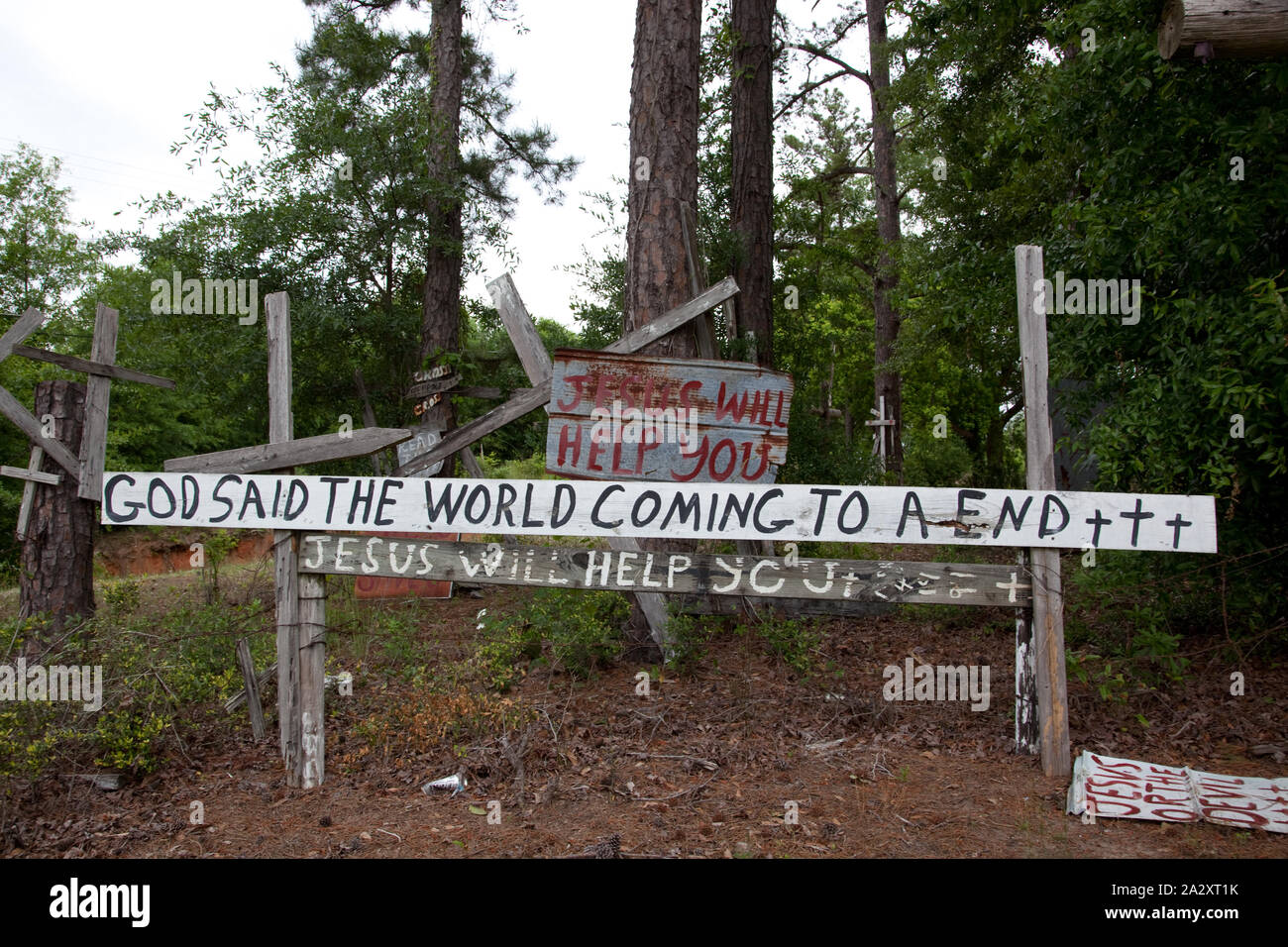 Ruvido croci di legno e alla pelatura mano-letterati segnaletica recante la Bibbia sacra scrittura frammenti sono inchiodati alla recinzione, alberi e ogni altro nel tardo W.C. Il riso della Croce stark giardino, Prattville, Alabama Foto Stock