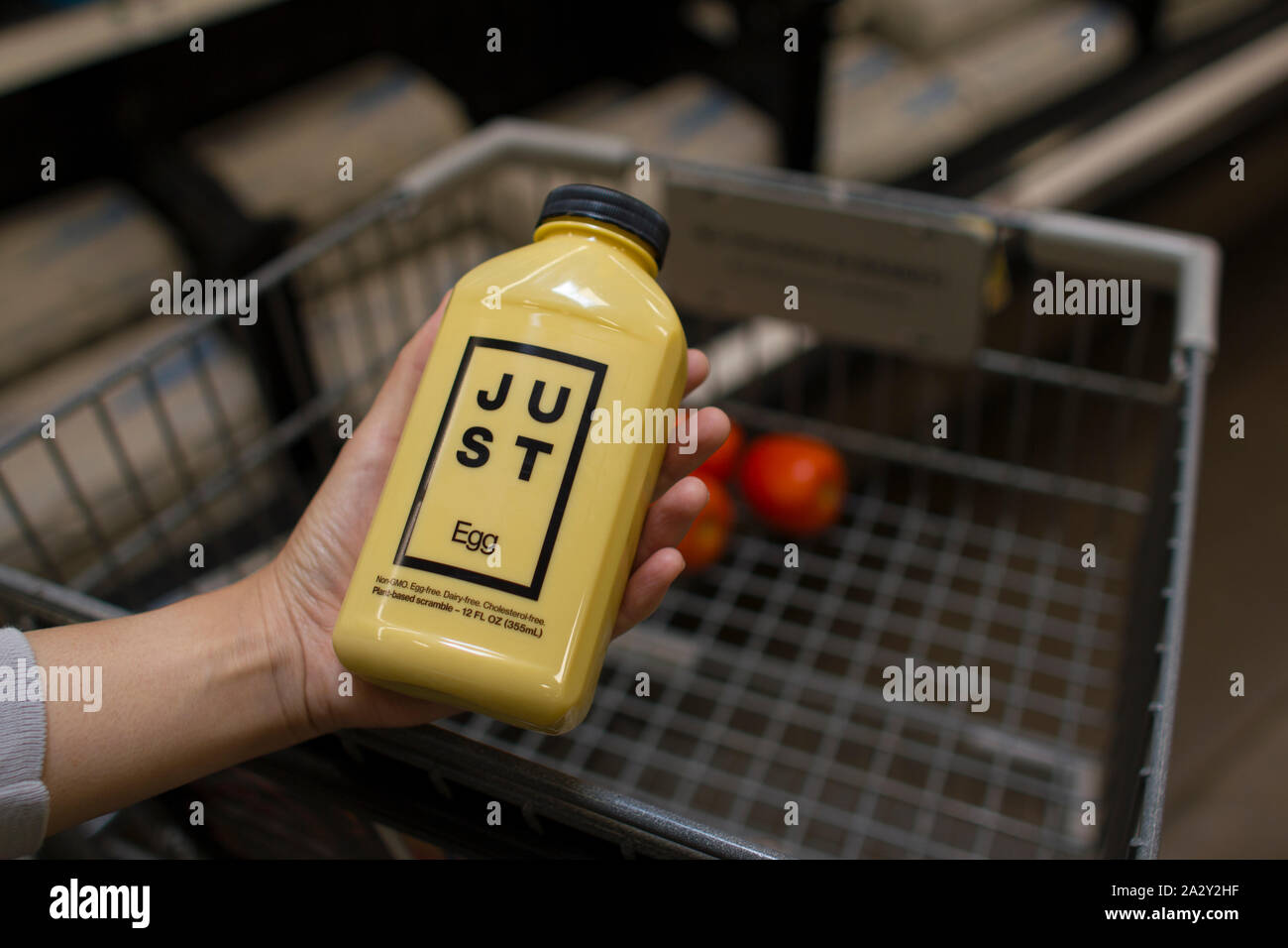 Tigard, Oregon, Stati Uniti d'America - 28 agosto 2019: un acquirente sceglie una bottiglia di uovo appena a base di vegetali in scramble a Fred Meyer fruttivendolo. Foto Stock