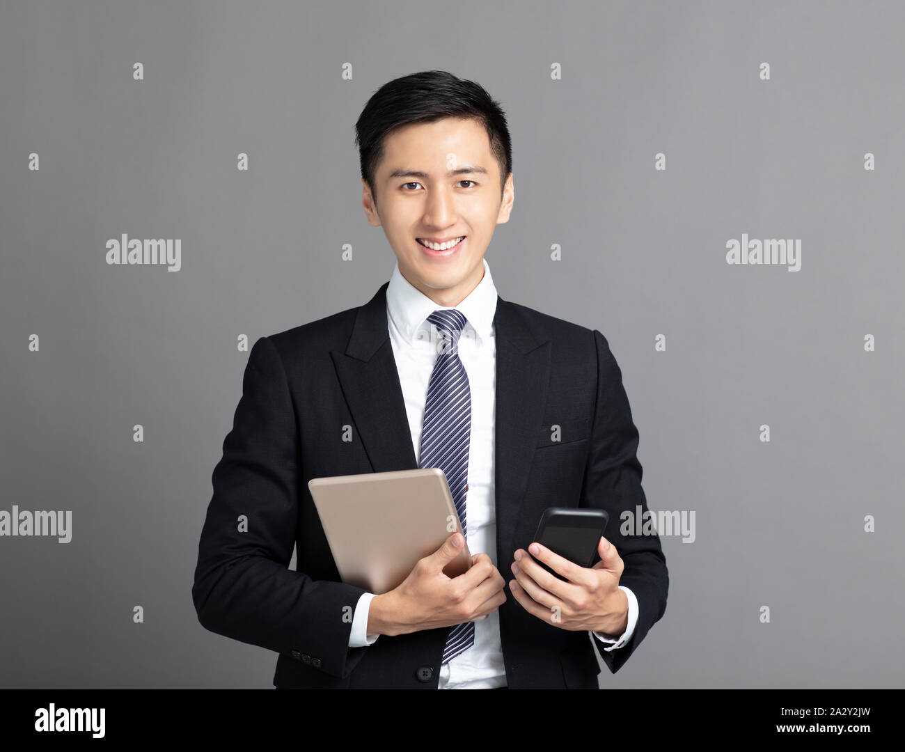 Giovane uomo d affari azienda smart phone e tablet pc Foto Stock