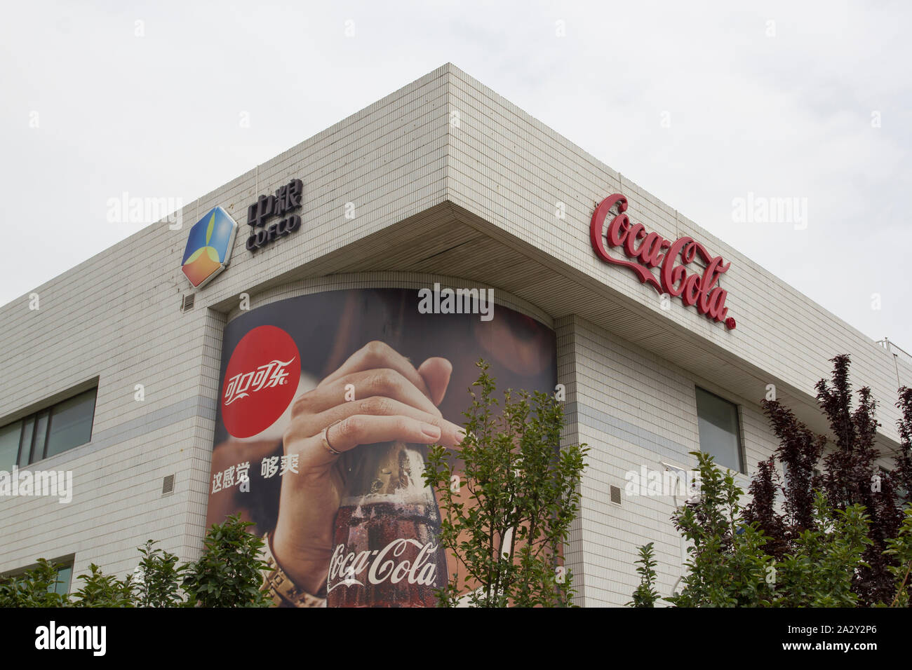 Segni di COFCO (China National Cereals, Oils and derrate alimentari Corporation) e Coca-cola visti presso lo stabilimento di Pechino della joint venture COFCO-Coca-Cola. Foto Stock