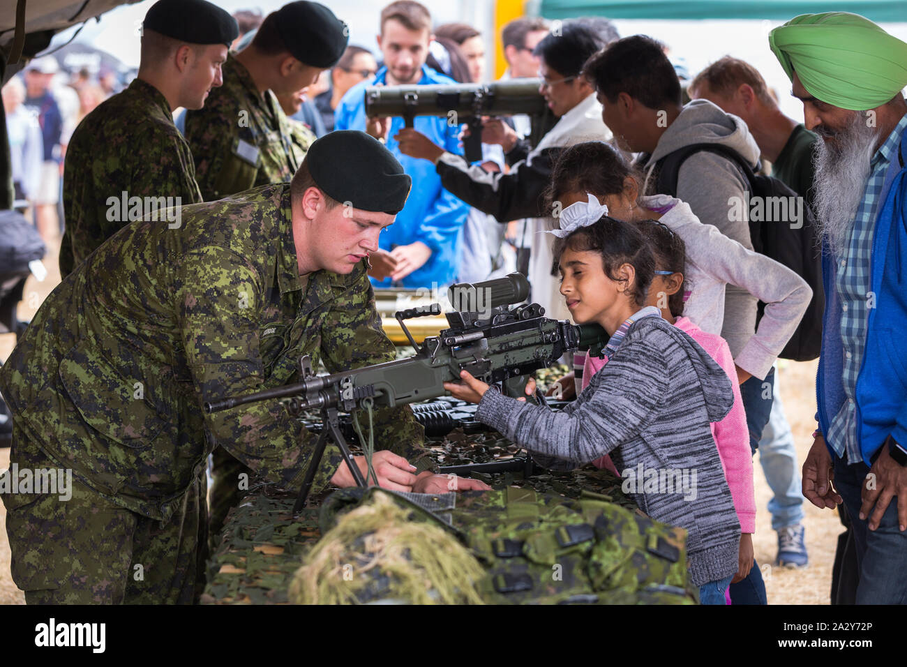 ABBOTSFORD, BC, CANADA - 11 AGOSTO 2019: Un soldato delle forze armate canadesi che mostra ai bambini un fucile automatico all'Abbotsford International Airshow. Foto Stock