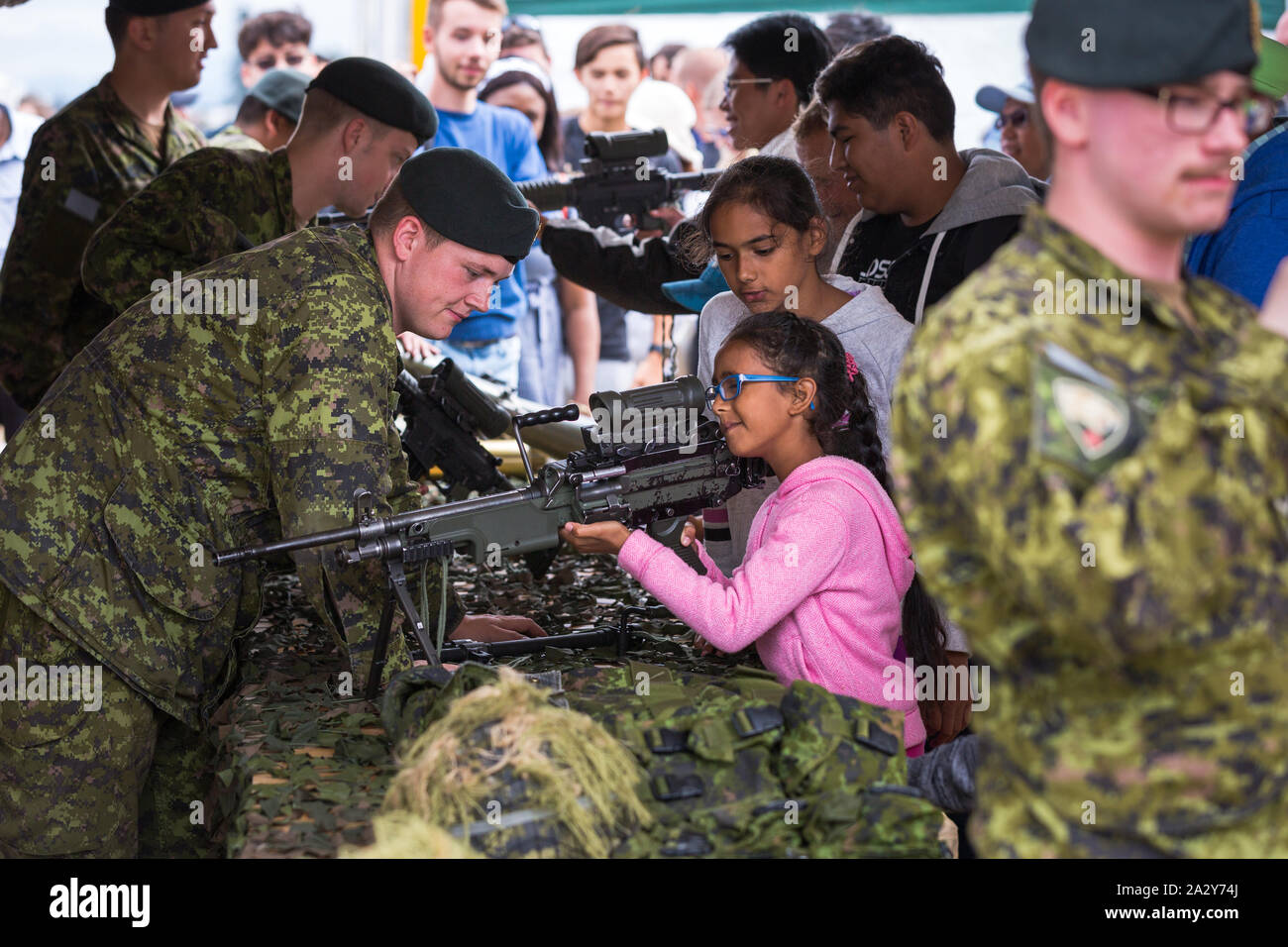 ABBOTSFORD, BC, CANADA - 11 AGOSTO 2019: Un soldato delle forze armate canadesi che mostra ai bambini un fucile automatico all'Abbotsford International Airshow. Foto Stock