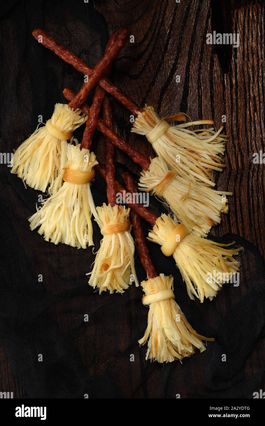 Scopa delle streghe di formaggio affumicato suluguni e salame. Idea originale Halloween snack. Foto Stock