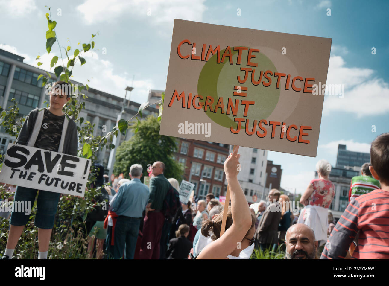 Il dimostratore con giustizia climatica migrante targhetta giustizia, xx settembre del clima globale sciopero, Piazza del Mercato Vecchio, Nottingham East Midlands, Inghilterra Foto Stock