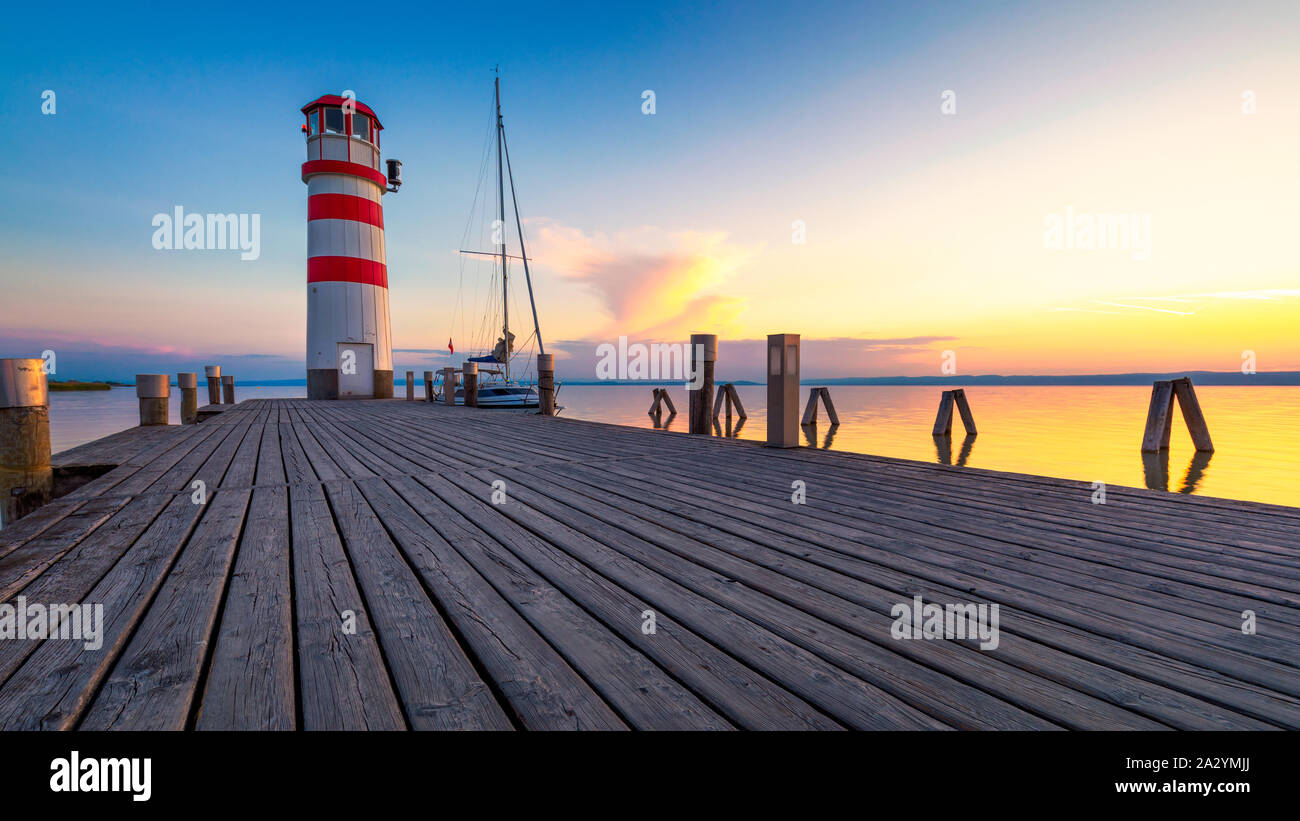 Faro di lago di Neusiedl, Podersdorf am See, Burgenland, Austria. Faro al tramonto in Austria. Il molo di legno con il faro in Podersdorf sul lak Foto Stock