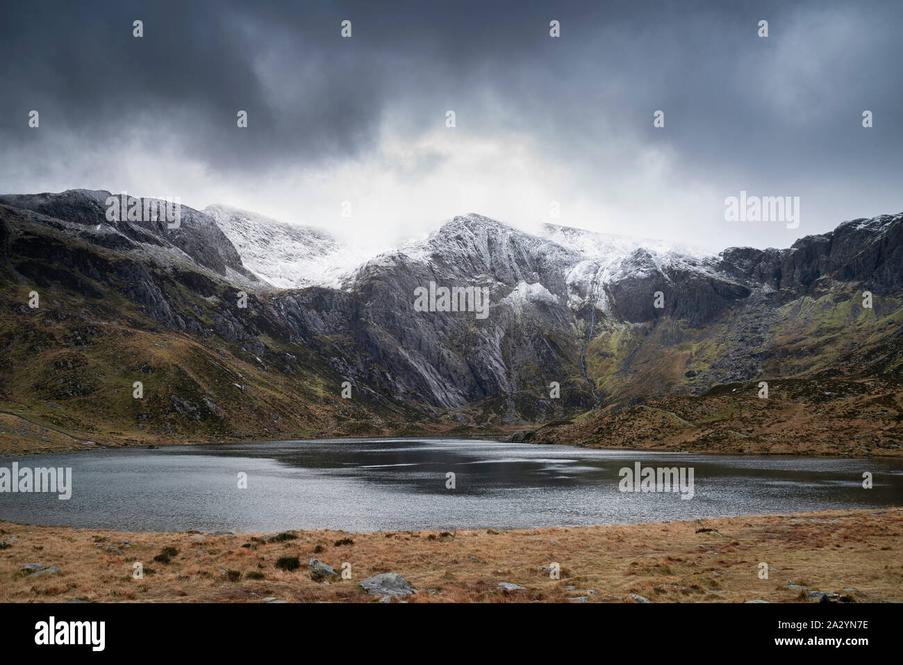 Incredibile drammatico paesaggio invernale immagine del Llyn Idwal e nevato Glyders Mountain Range in Snowdonia Foto Stock