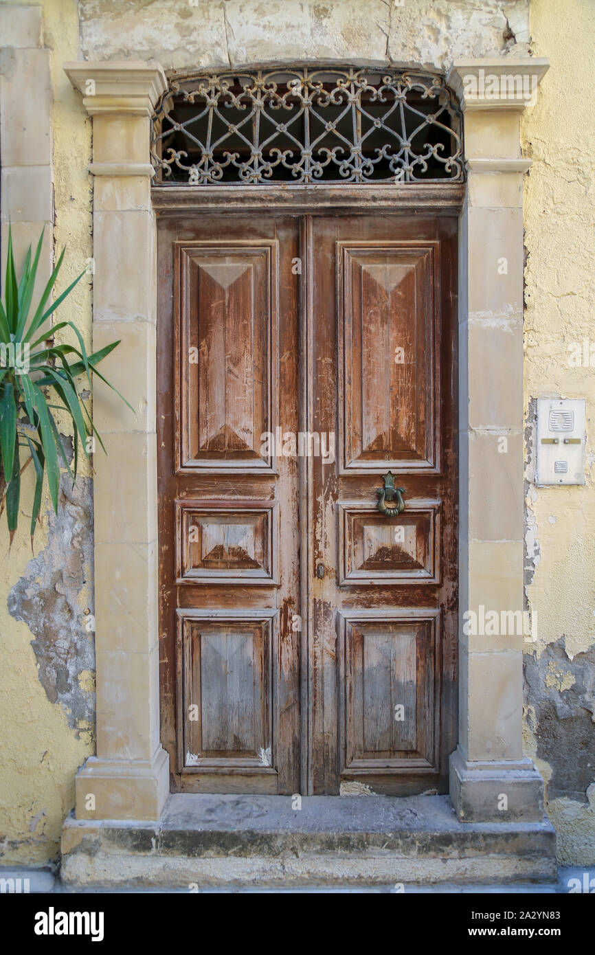 Vecchio brown porte in legno incorniciata da muri in pietra Foto Stock