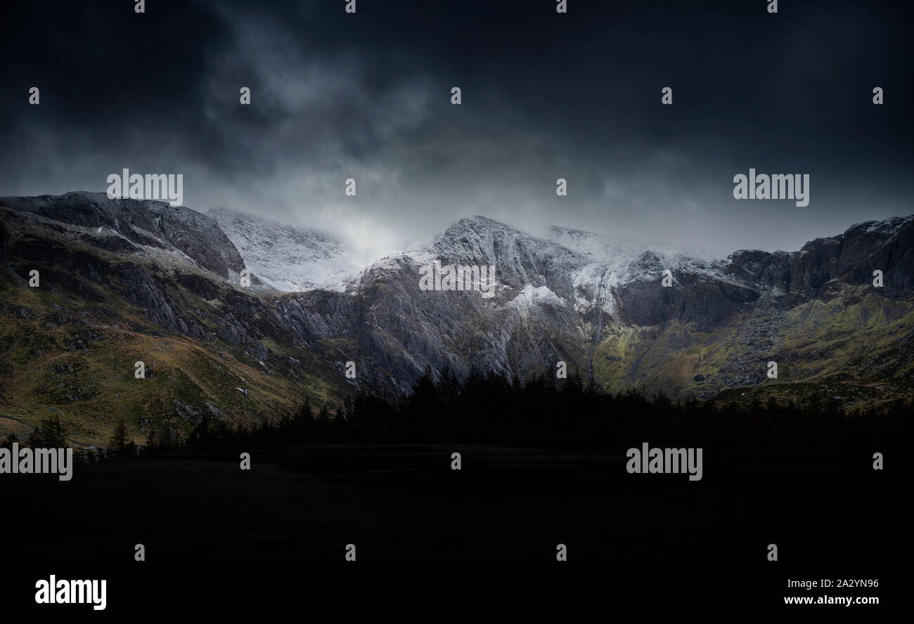 Incredibile drammatico paesaggio invernale immagine del Llyn Idwal e nevato Glyders Mountain Range in Snowdonia Foto Stock