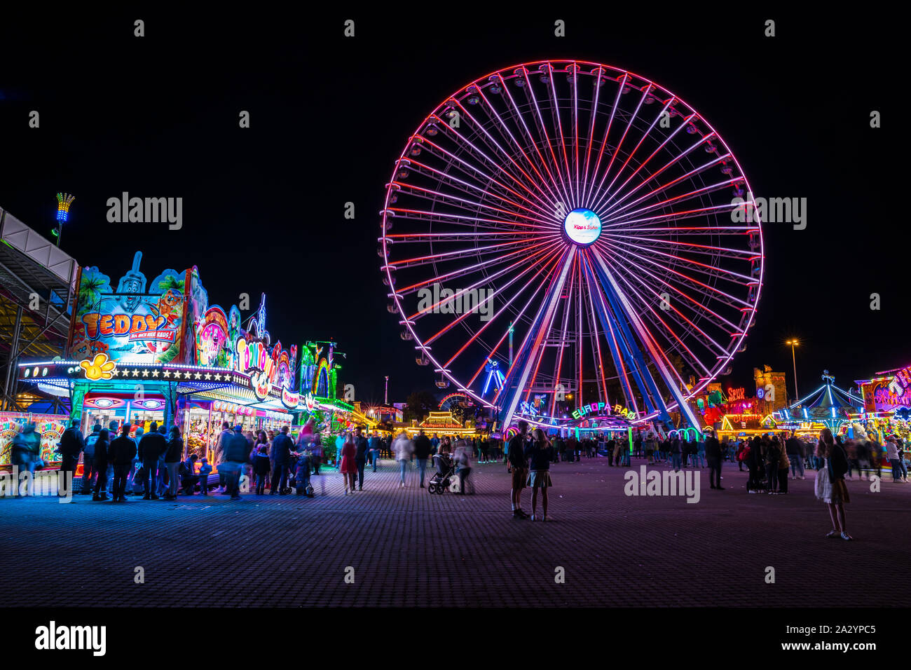 Stoccarda, Germania, 3 ottobre 2019, molte persone godono colorate ruota di grandi dimensioni e offre cibo a canstatter wasen oktoberfest festival folk di notte Foto Stock