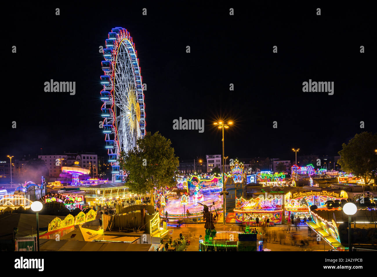 Stoccarda, Germania, 3 ottobre 2019, Canstatter wasen oktoberfest folk festival illuminando la notte con molti giostra ruota grande e offre cibo b Foto Stock