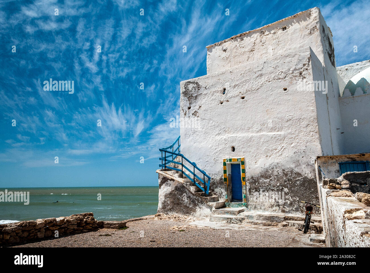 Un vecchio decrepito edificio bianco che si affaccia sul mare vicino alla spiaggia di Sidi Kaouki Foto Stock