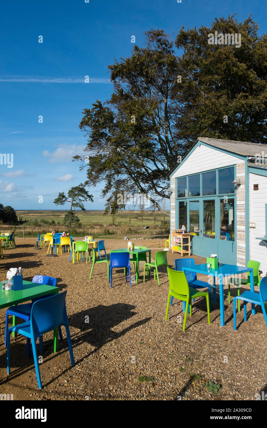 Blu, verde e giallo e i tavoli e le sedie fuori Wiveton Hall cafe, Wiveton, North Norfolk, Regno Unito Foto Stock