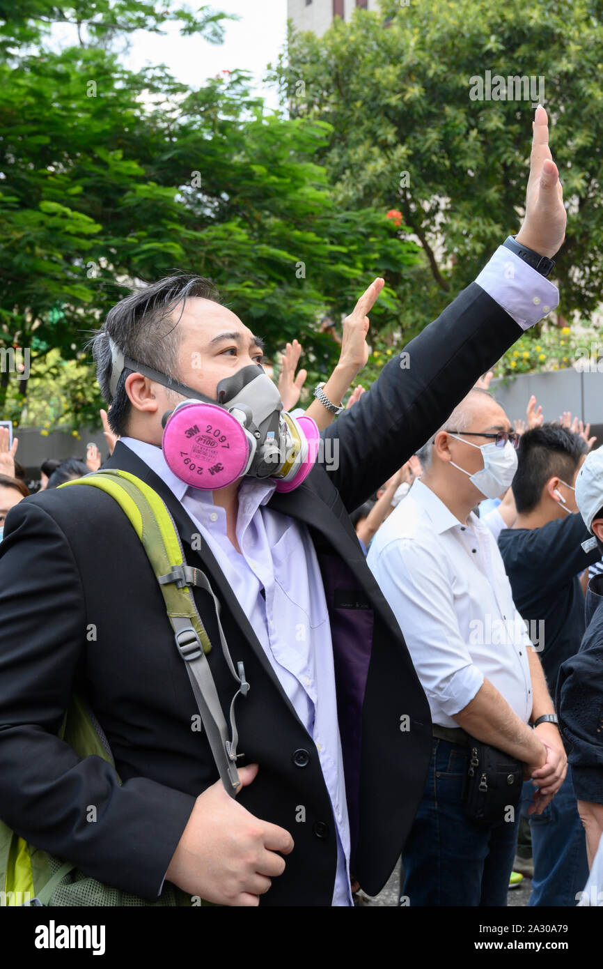 Hong Kong. Il 4 ottobre 2019. Migliaia di persone si sono radunate nel centro di Hong Kong e durante le ore del pranzo hanno marciato attraverso il quartiere centrale degli affari di protesta contro l'uso di alimentazione di emergenza per il divieto di indossare delle maschere durante le proteste. I manifestanti hanno le mani alzate come essi chant "cinque richieste e non uno di meno". Foto Stock