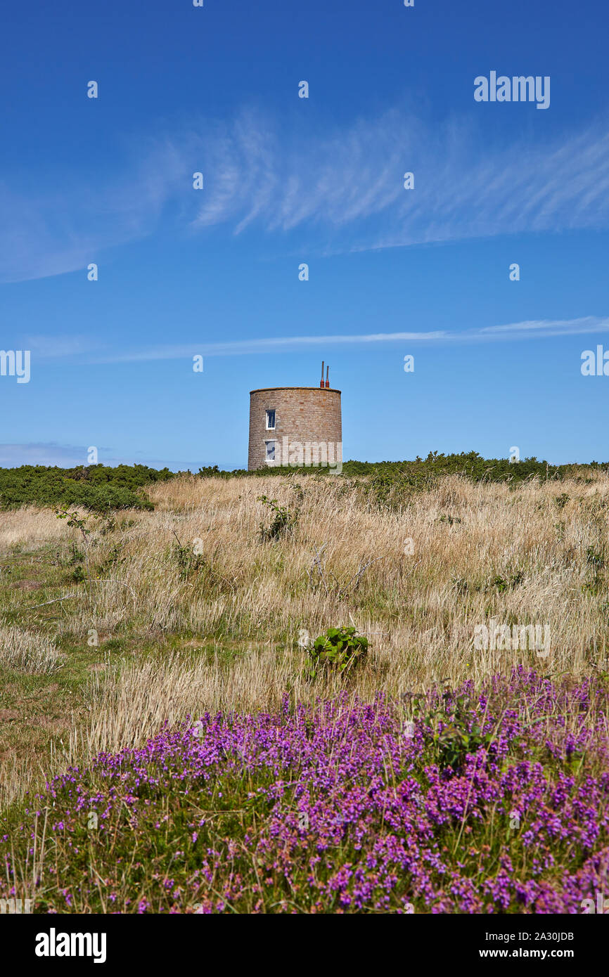 Paesaggio con una casa convertita da una pietra rotonda torre, originariamente un calcestruzzo sentry post nella ex Germania campo di concentramento SS Lager Sylt Foto Stock