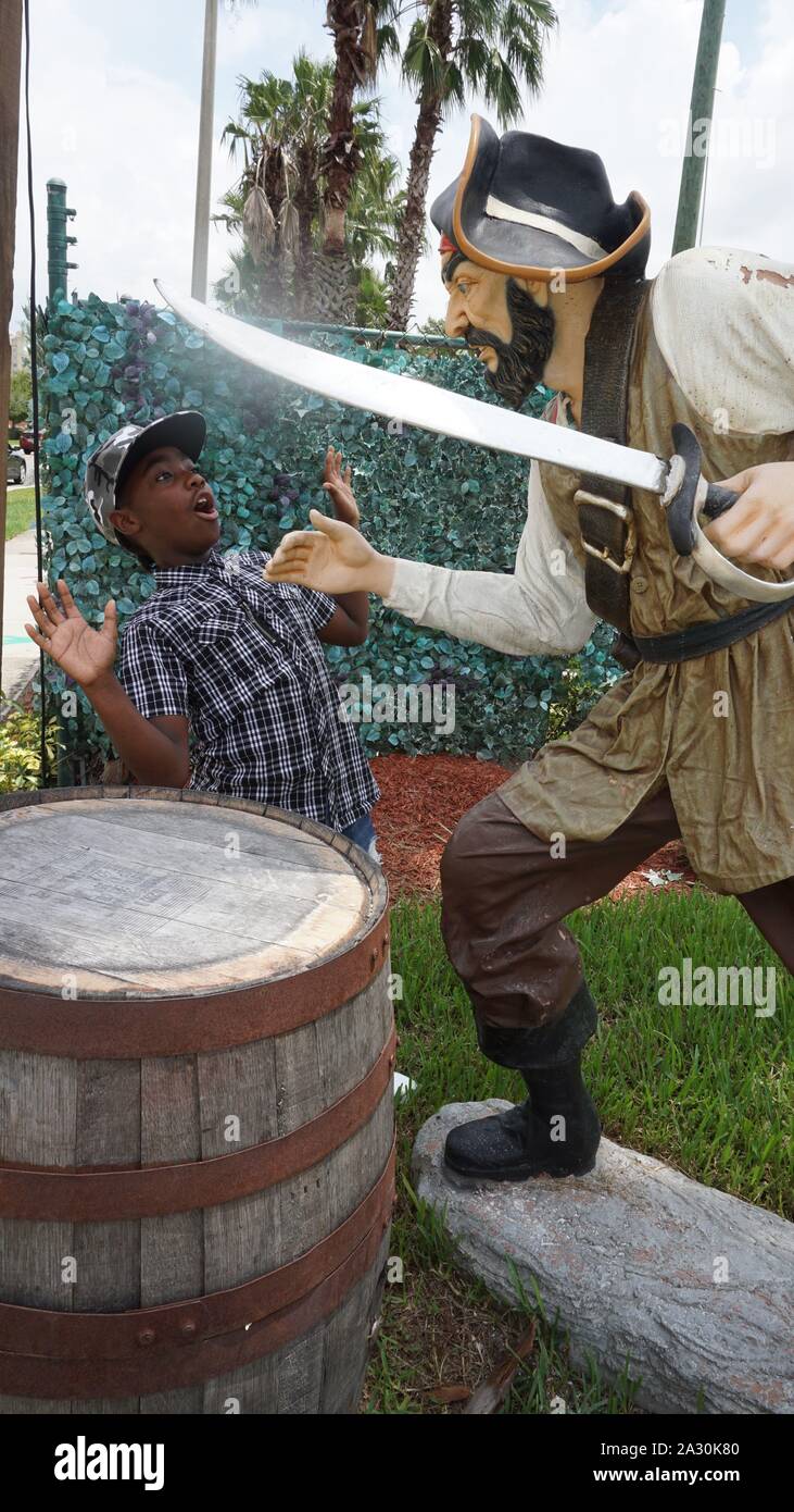 Giovane ragazzo in posa accanto alla statua del pirata alla Cena dei Pirati Show di Orlando Foto Stock