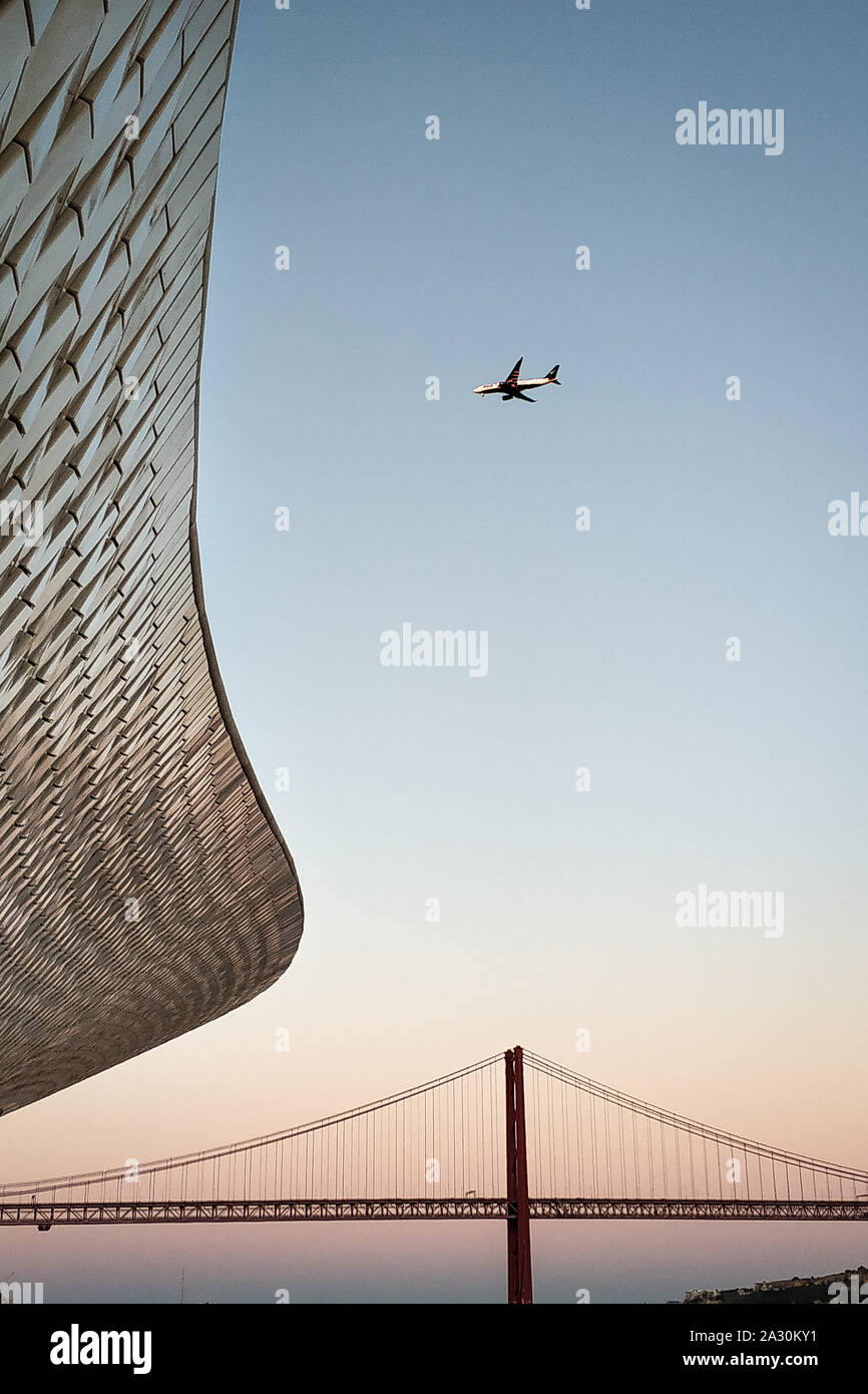Aprile 25 ponte sopra il fiume Tago in Portogallo. Nella foto, il tetto del MAAT Museum e il piano nel cielo. Foto Stock