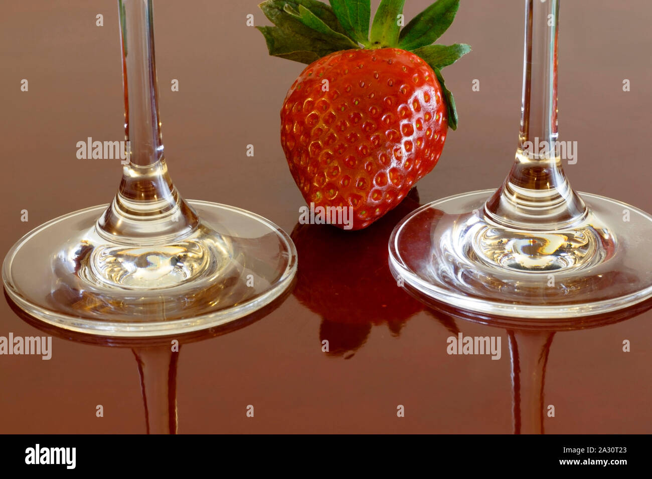 Due wineglasses e fragola su un tavolo Foto Stock