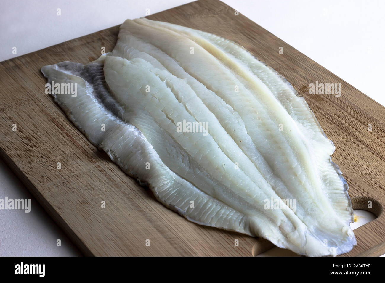 Fresche, materie non cotti passera di mare filetto di pesce sul tagliere Foto Stock