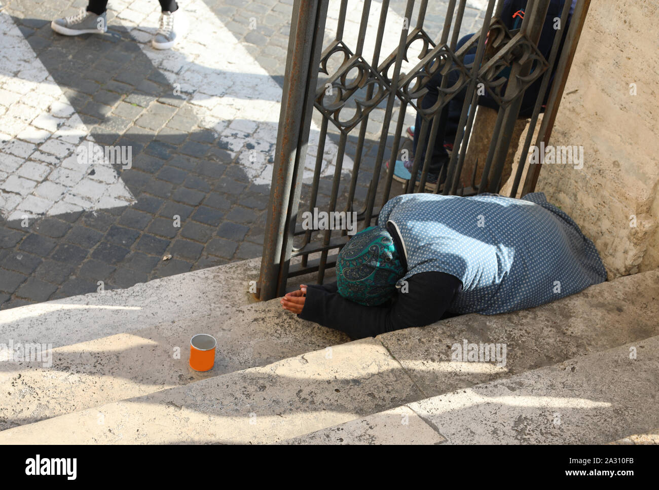 Donna anziana chiede soldi in città Foto Stock