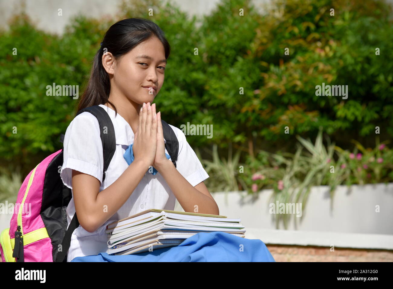 Una variegata Studentessa in preghiera Foto Stock
