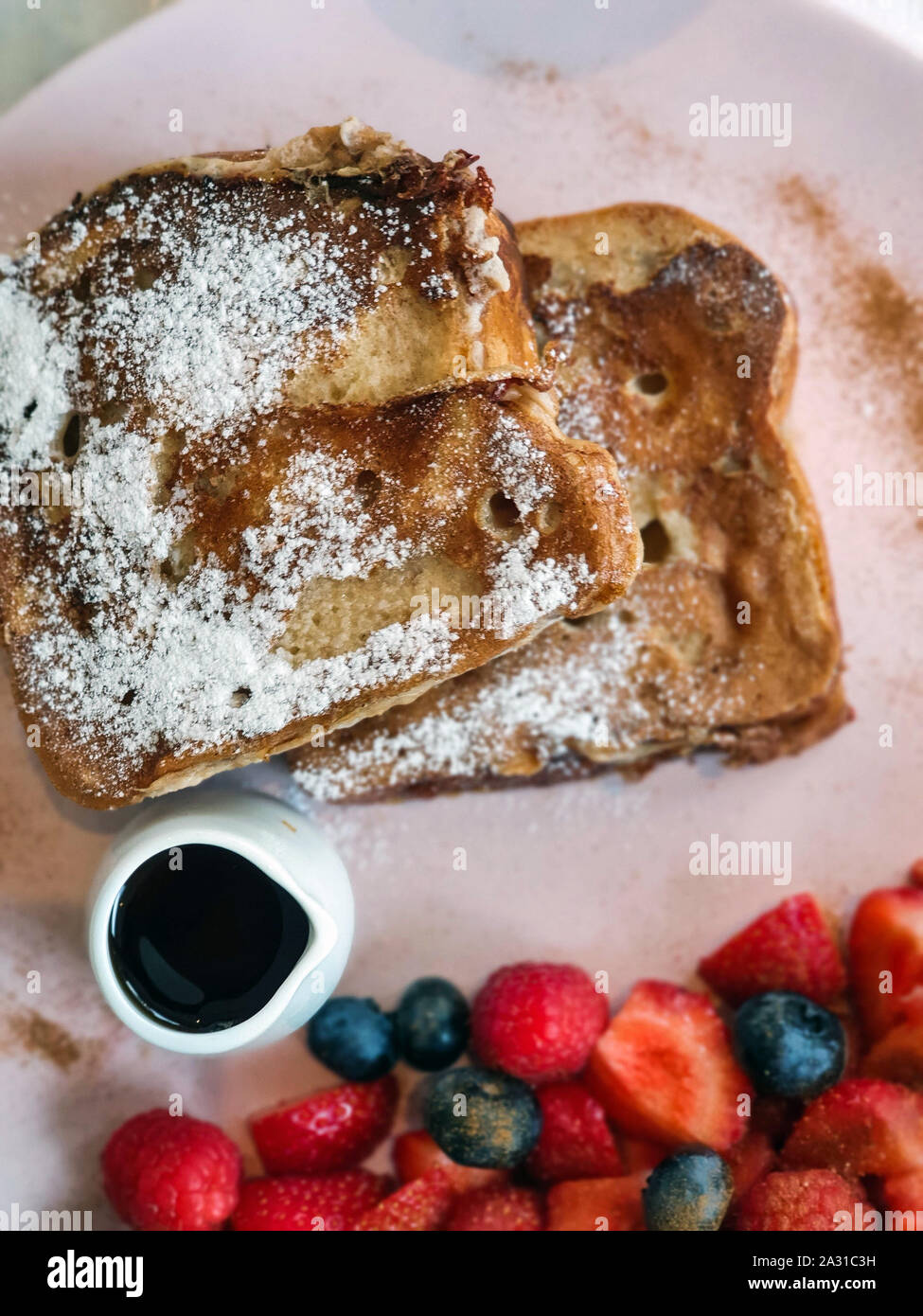 La prima colazione di toast alla francese con frutti di bosco freschi e sciroppo d'acero Foto Stock