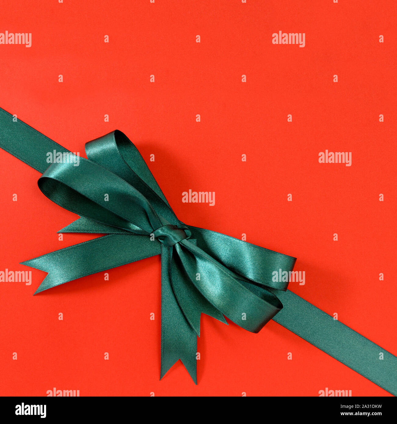 Verde regalo ribbon bow angolo diagonale rossa sullo sfondo della carta Foto Stock