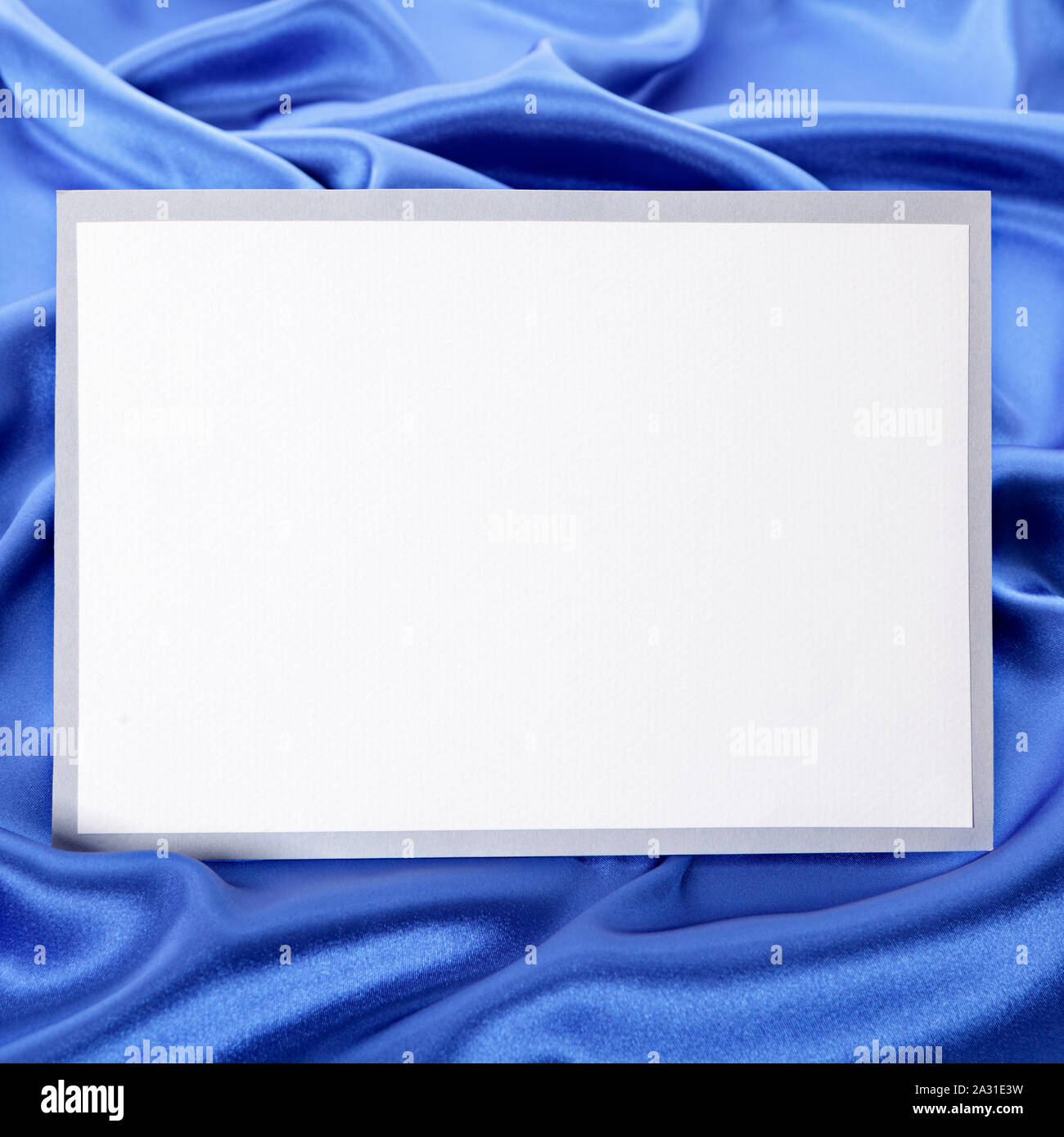 Blank biglietto di auguri o un invito con in raso blu sullo sfondo. Foto Stock