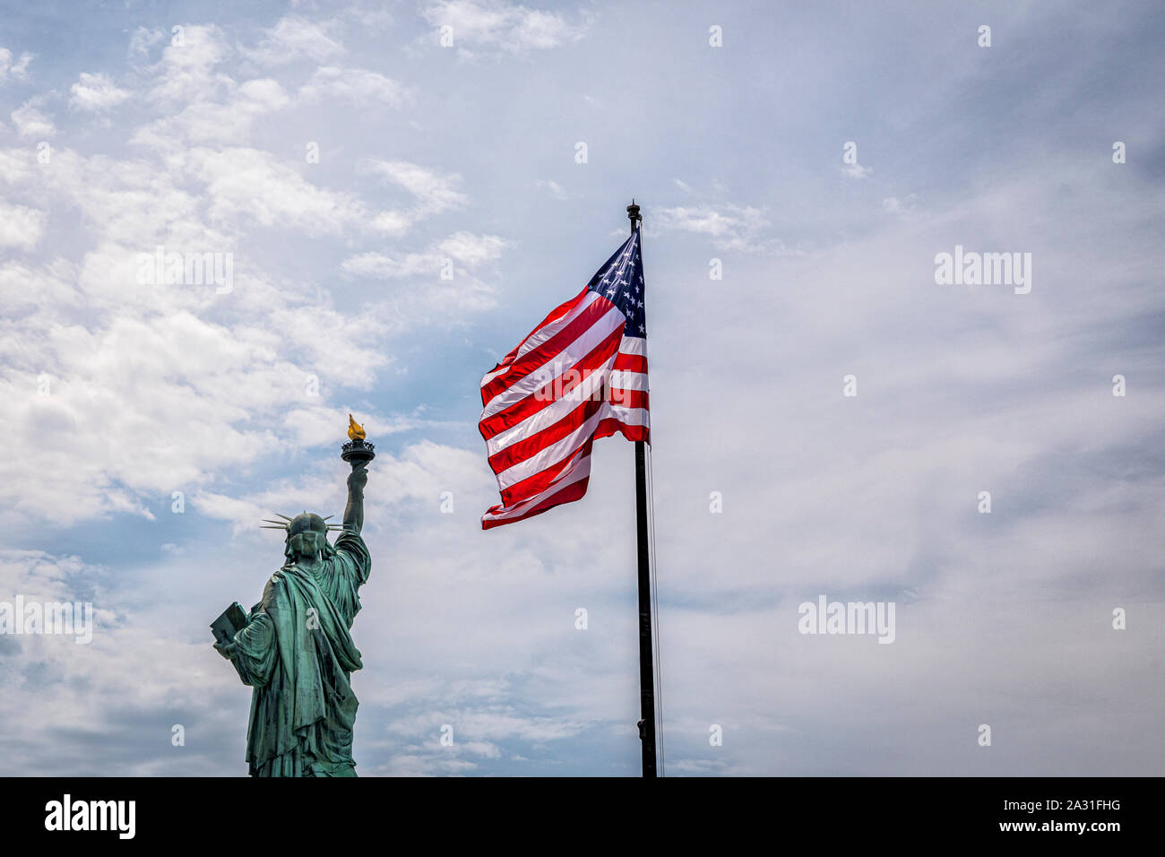 La Statua della Libertà e il flag USA, New York City, Stati Uniti d'America. Foto Stock