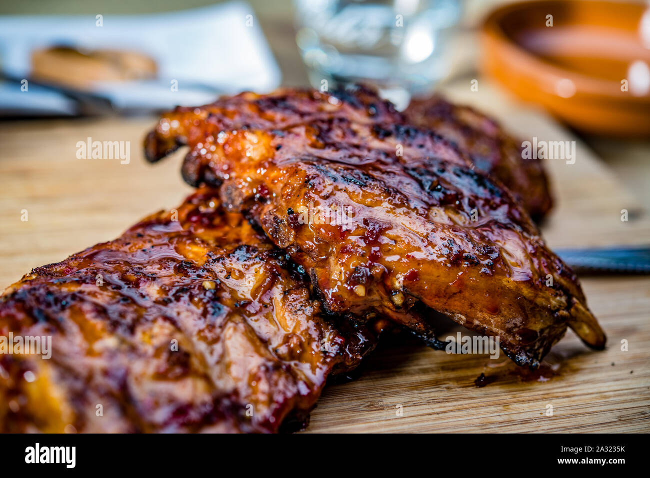 Close up dorata succosa arrosto di costine sul piatto di legno Foto Stock