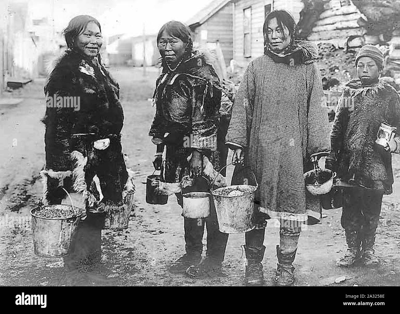 Eschimese berry raccoglitori tre donne e un ragazzo in piedi in strada con i secchi pieni di bacche Nome Alaska tra 1903 e 1906 (AL+CA 21). Foto Stock
