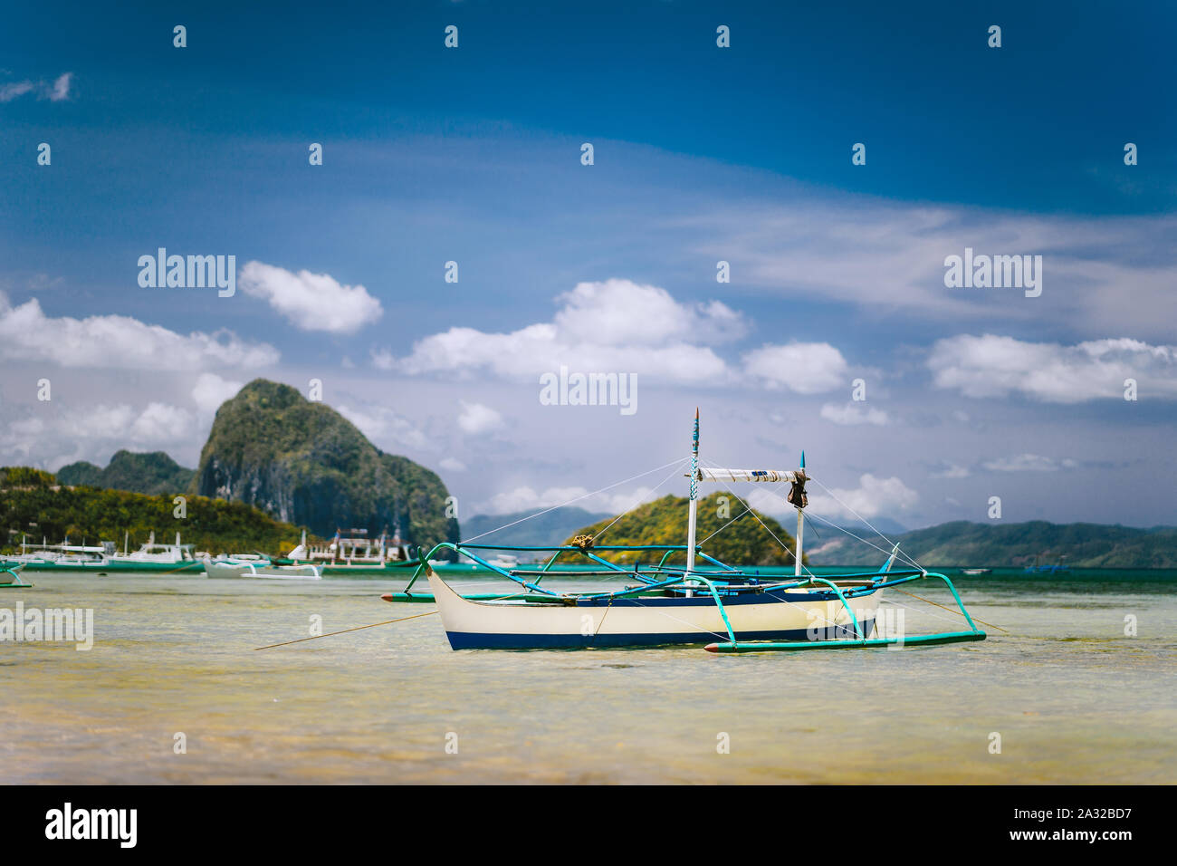 Banca tradizionale barca dei pescatori in laguna poco profonda sulla spiaggia Corong. Nido, Filippine. Cielo blu e nuvole sopra arcipelago Bacuit Foto Stock