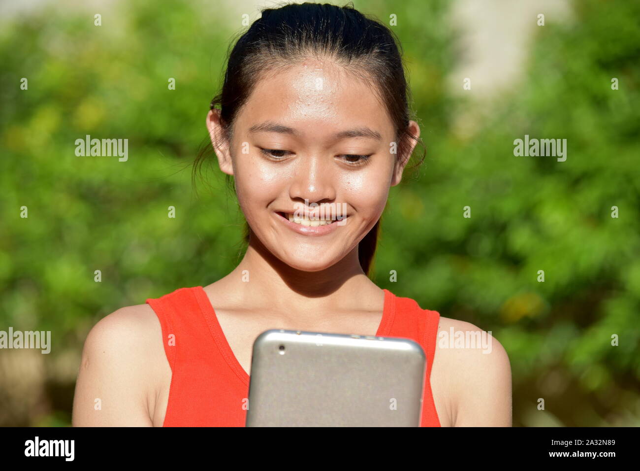 Sorridente carina ragazza asiatica con Tablet Foto Stock