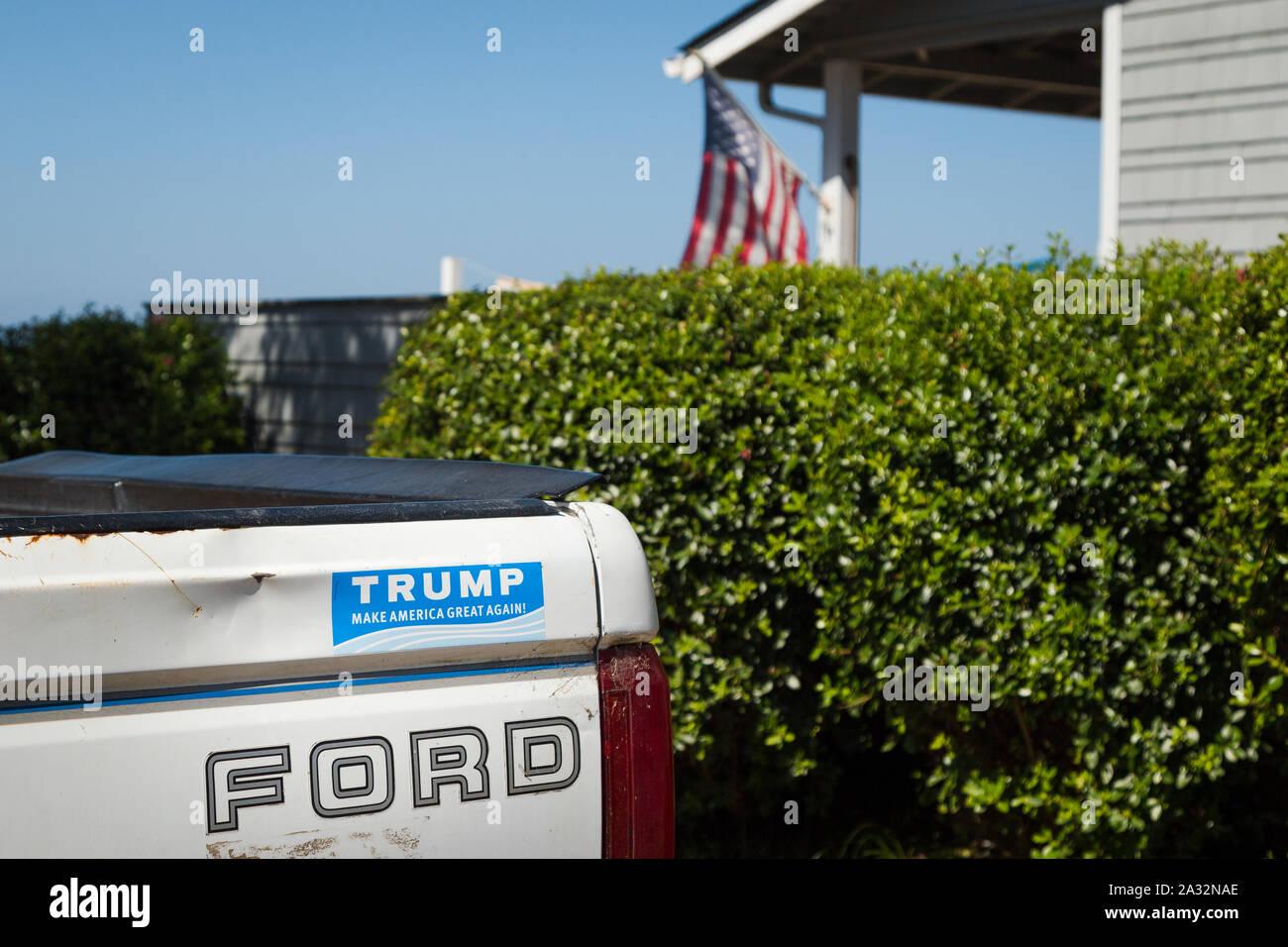 LINCOLN CITY O, STATI UNITI D'AMERICA - Agosto 26, 2019: una Ford pickup truck con un pro Trump paraurti adesivo e una bandiera americana in background. Foto Stock