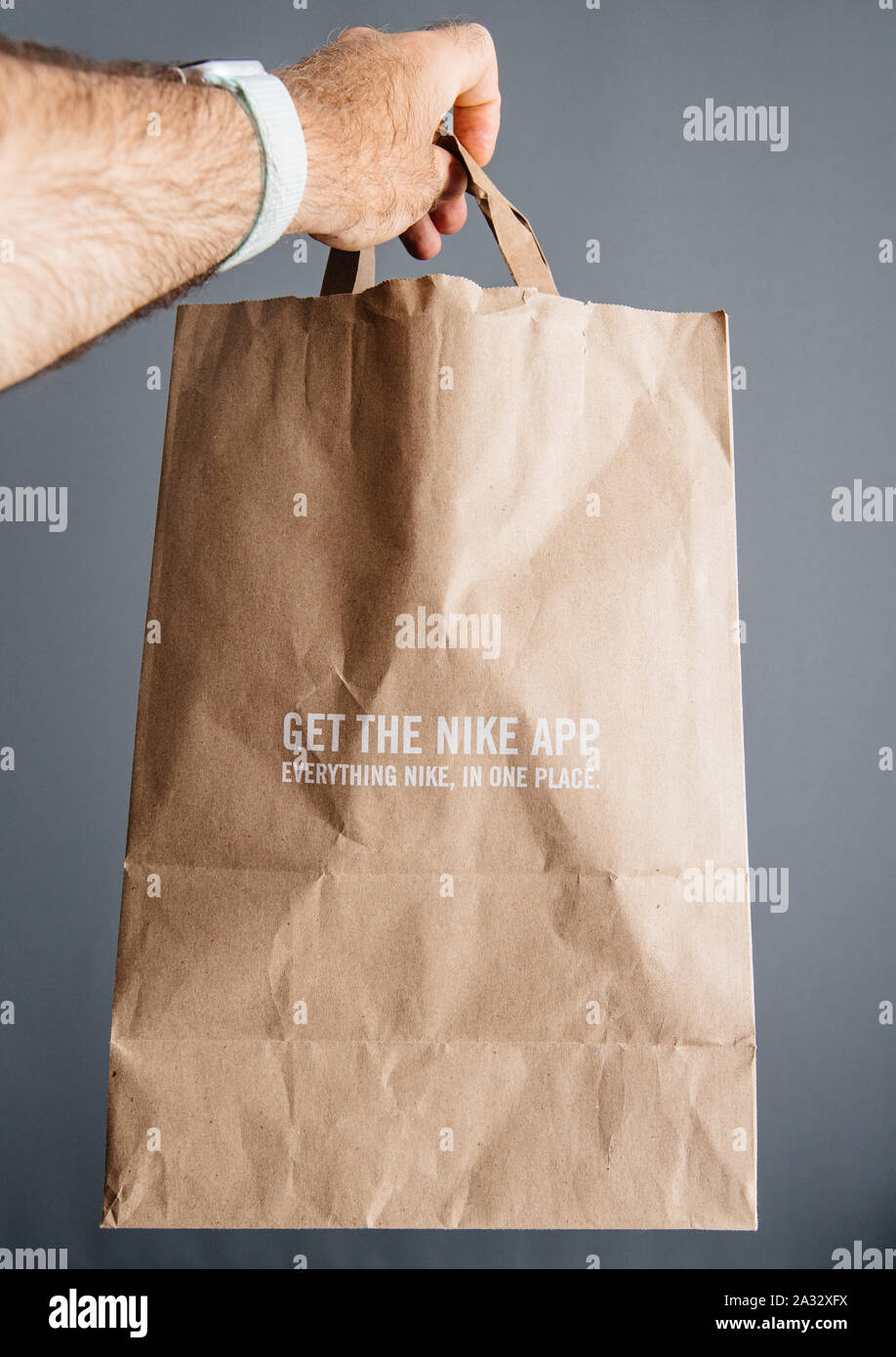 Parigi, Francia - 30 Sep. 2019: Maschio mano azienda nuove Nike Plus  sacchetto di carta con nuove