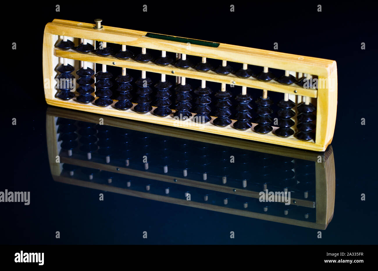 Abacus con perle nero su nero superficie riflettente Foto Stock