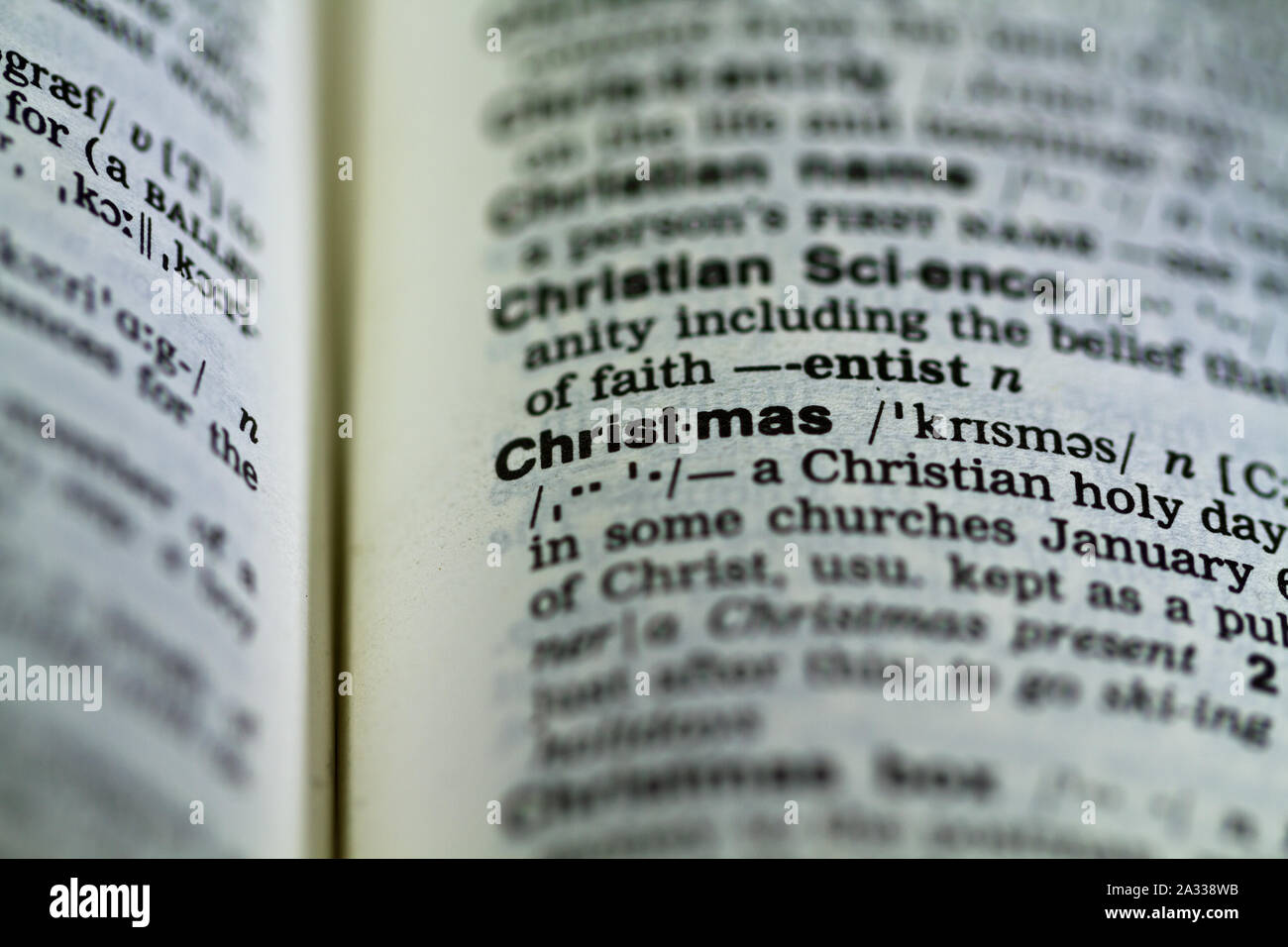 La parola Merry Christmas definizione nel dizionario vecchio sotto la lente di ingrandimento Foto Stock