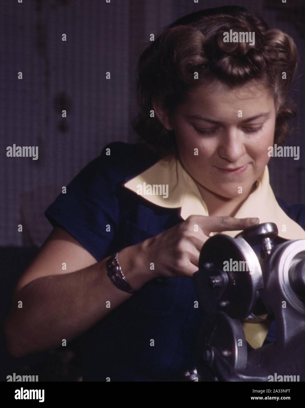 Faccia particolare, una giovane donna dipendente di North American Aviation, Incorporated, operando sul carrello di atterraggio del meccanismo di movimentazione di una P-51 aereo da combattimento, Inglewood, Calif (ritagliate). Foto Stock