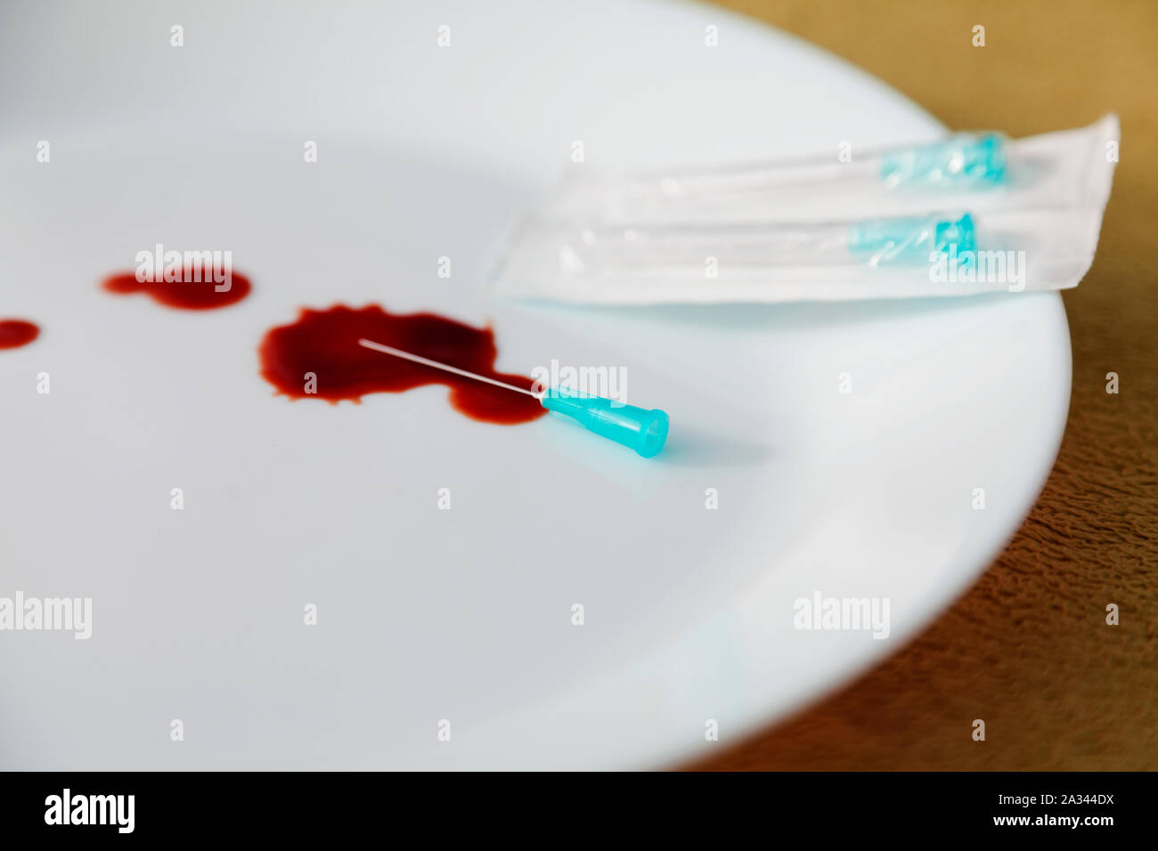 Ospedale aghi e sangue su di una piastra, qualcuno deve essere stato ferito Foto Stock