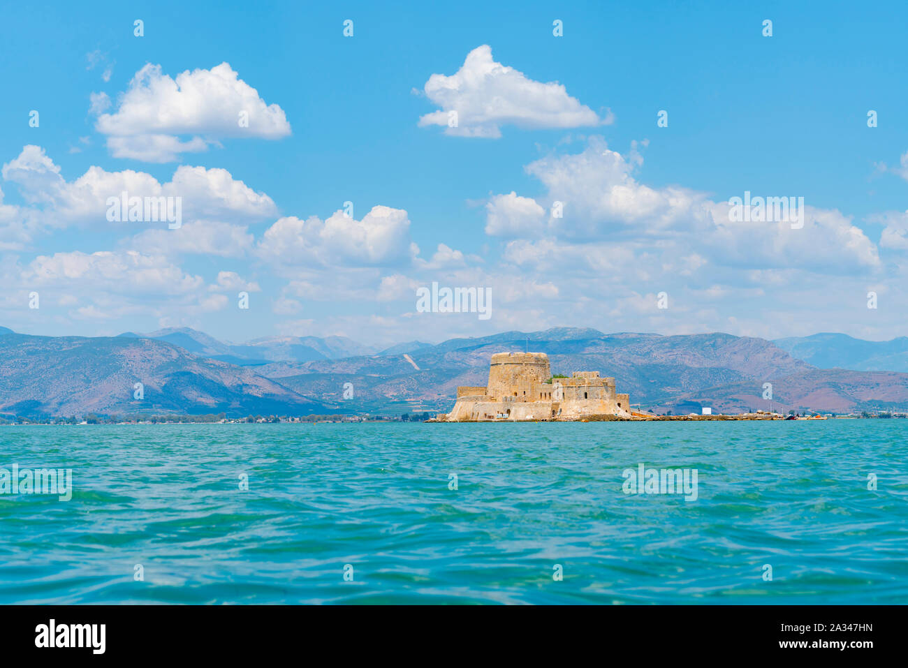 Bourtzi antica fortezza di costa di Nafplio sul Greco Peloponneso attraverso acque turchesi del Mediterraneo. Foto Stock