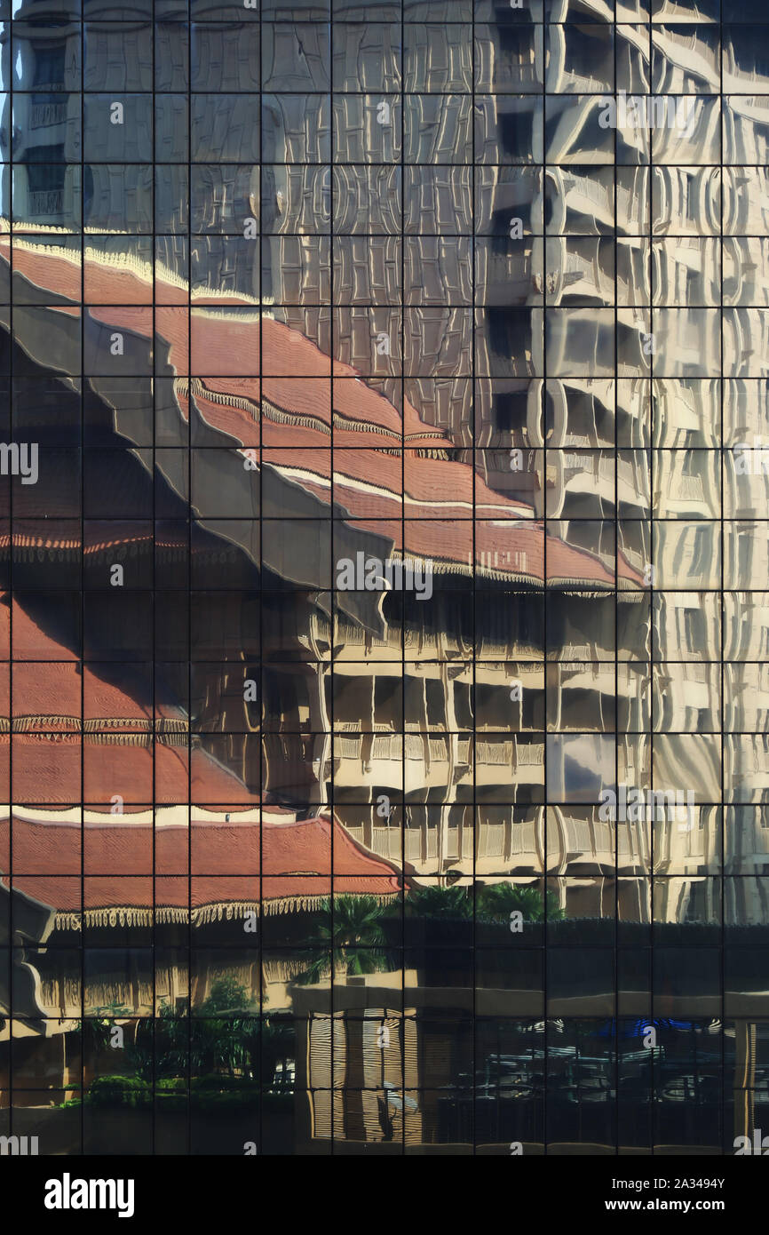 Edificio moderno curtain wall riflettendo retrò edificio di stile tradizionale in facciata. pulire vetri riflettenti del pannello in un'altra costruzione e reso un Foto Stock