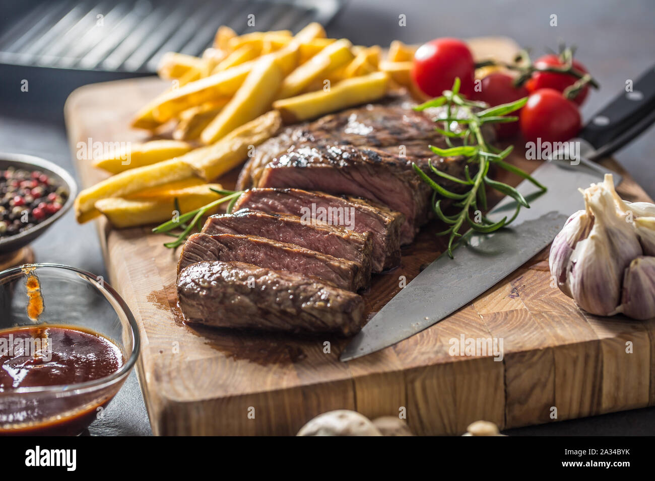 Carni bovine nervatura occhio bistecca con patate arrosto bbq sauce funghi all'aglio e spezie. Foto Stock