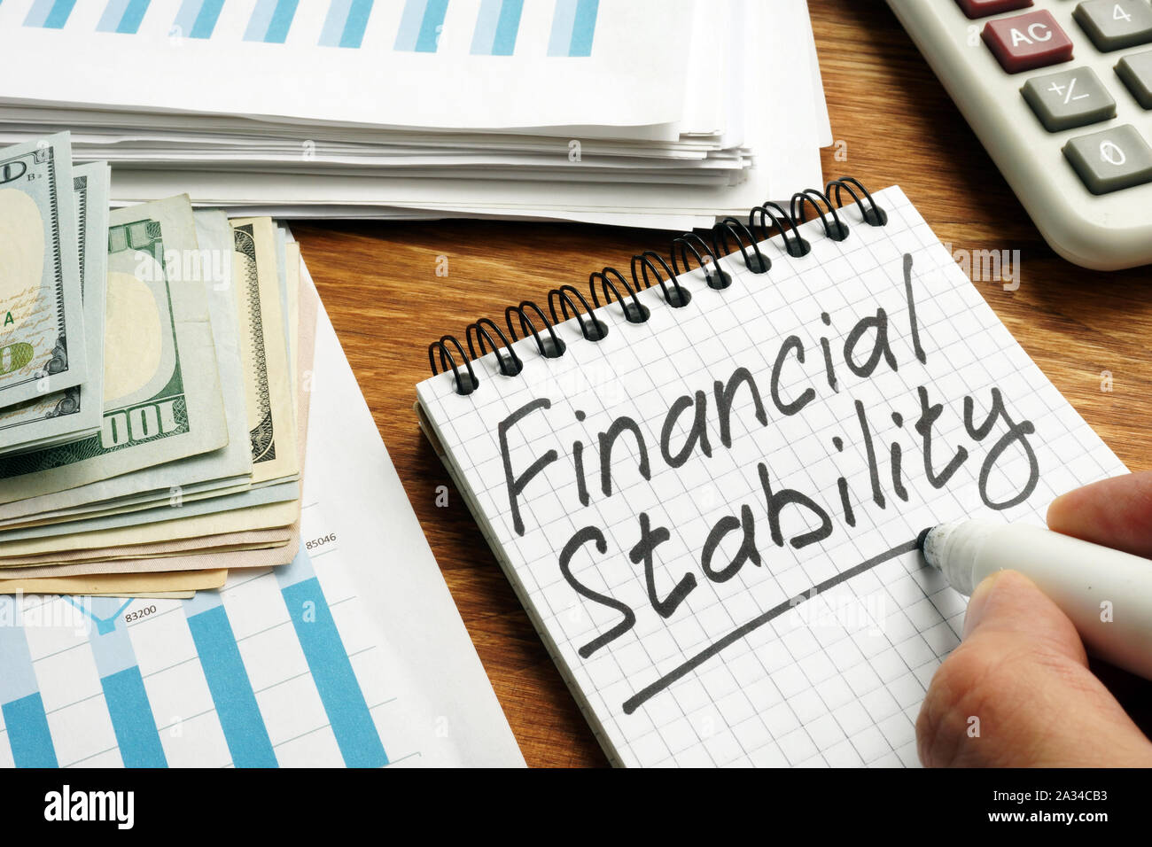 Uomo scrive la stabilità finanziaria nella nota. Foto Stock