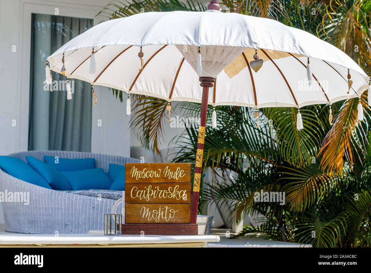 Legname cocktail di calligrafia segno per un banco di bar per un matrimonio. Bianco grande ombrellone. Destinazione tropicale matrimonio. Bali, Indonesia. Foto Stock