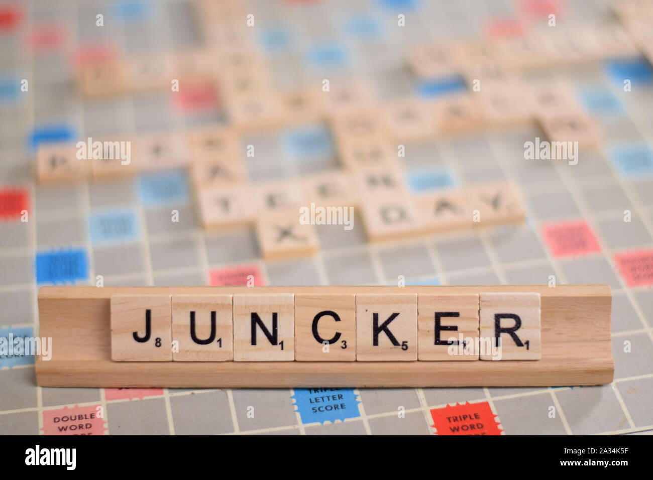 Il nome 'JUNCKER" (Jean Claude Juncker, ex presidente della Commissione europea) in legno piastrelle scrabble su un rack. Sfondo con copyspace. Foto Stock