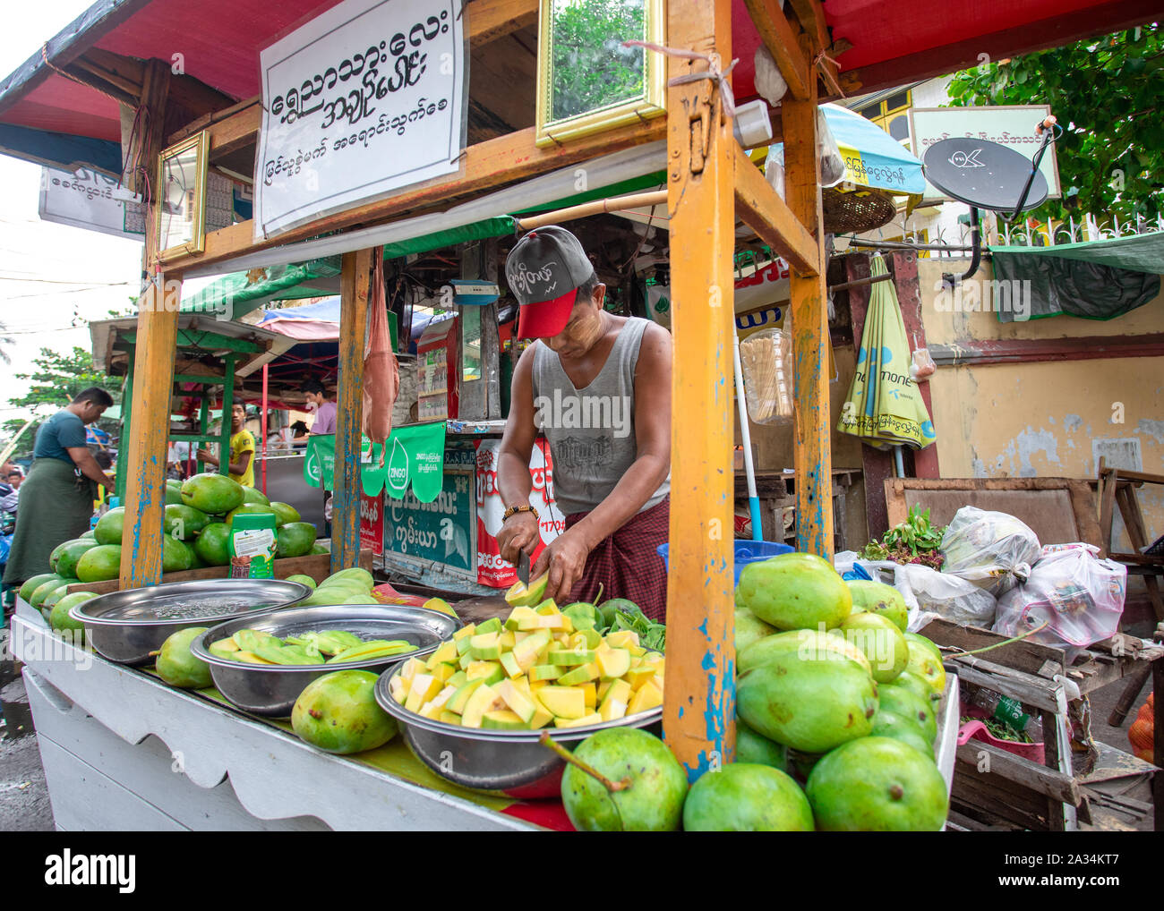 L'uomo la preparazione di Mango e vendere sulla strada di Yangon, la Birmania. Tradizionale cibo di strada a Myanmar. Foto Stock